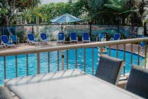 a pool with chairs and a table and an umbrella at The Rocks Resort 1C in Gold Coast