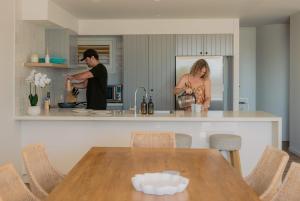 a man and woman in a kitchen with a table at The Rocks Resort 1C in Gold Coast