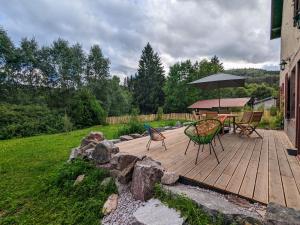 JussaruptにあるGîte Vosgien Rénové avec Jardin, Proche Gérardmer et Activités de Plein Air - FR-1-589-600の木製デッキ(テーブル、傘付)