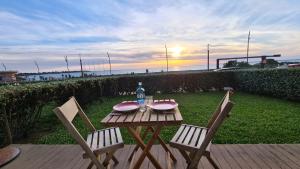 サン・ミシェル・シェフ・シェフにあるIdéal en amoureux, vue mer et jardin ! Appartement lumineux à Tharon-Plageの木製テーブル(椅子2脚付)、ボトル入り飲料水1本
