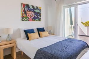 um quarto com uma cama e um quadro na parede em Vita Portucale ! Costa Caparica Duplex Sea View em Almada