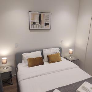 1 dormitorio con 1 cama blanca y 2 lámparas en OPO Bolhao Flats by Destiny Houses, en Oporto