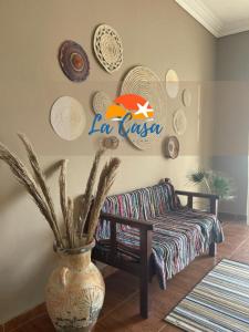 a living room with a couch and plates on the wall at La Casa Guest House in Marsa Alam City