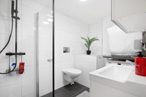 a white bathroom with a toilet and a sink at apartment Bergen in Bergen