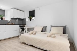 a white bedroom with a bed and a kitchen at apartment Bergen in Bergen