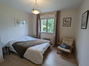 DounouxにあるMaison Plain-Pied à 10 min d'Epinal: Jardin Clos, BBQ, WIFI, Draps et Ménage Inclus - FR-1-589-606のベッドと椅子と窓のある寝室