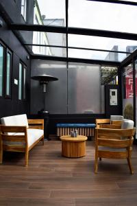 a room with chairs and a coffee table andwindows at Hotel DC Feria in Bogotá