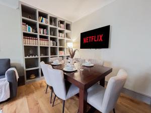 a dining room with a table and chairs and a tv at Stylish retreat in the heart of Notting Hill in London