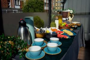 a table with bowls and plates of food on it at Hotel DC Feria in Bogotá