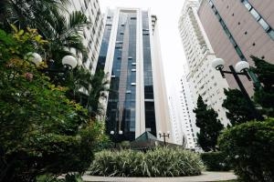 uma vista para um edifício alto com palmeiras e plantas em Apart-hotel 1710 - Le Premier Suítes - Jardim Paulista em São Paulo