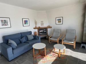 een woonkamer met een blauwe bank en 2 stoelen bij Las Palmeres 6 in Torroella de Montgrí