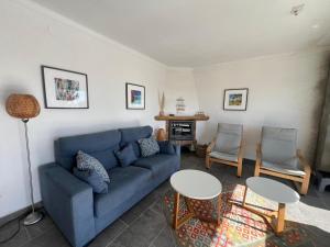 een woonkamer met een blauwe bank en 2 tafels bij Las Palmeres 6 in Torroella de Montgrí