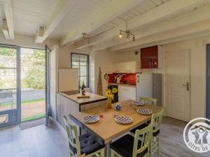 - une cuisine et une salle à manger avec une table et des chaises dans l'établissement Gîte Ingrandes-Le Fresne sur Loire, 2 pièces, 2 personnes - FR-1-622-67, à Ingrandes