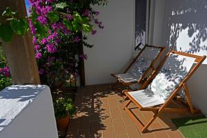 a pair of chairs sitting on a patio with flowers at Matriz Guest House in Portel