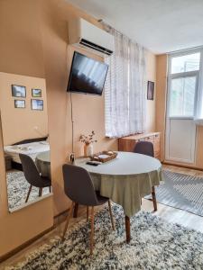 comedor con mesa, sillas y espejo en Студио апартамент Троян, en Troyan