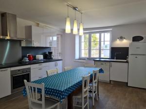 a kitchen with a table and chairs and a kitchen with white cabinets at Gîte Saint-Sigismond, 4 pièces, 6 personnes - FR-1-590-386 