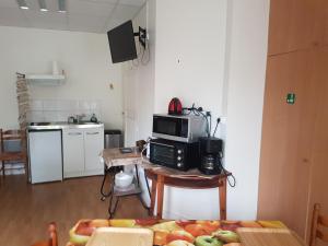 eine Küche mit einer Mikrowelle und einem Tisch mit Obst in der Unterkunft Gîte Bucy-Saint-Liphard, 1 pièce, 2 personnes - FR-1-590-413 