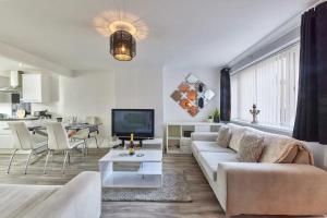 Cosford House - 3BR House in في Kenton: غرفة معيشة بيضاء مع أريكة وتلفزيون