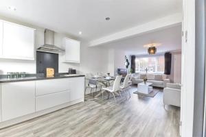 a kitchen and living room with a table and chairs at Cosford House - 3BR House in in Kenton