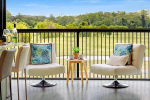 een balkon met twee stoelen en een tafel met uitzicht bij The Sanctuary - Family Retreat - Noosa Hinterland in North Arm