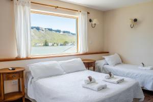 a room with two beds with towels on them at Hotel Kallfu by Nordic in Caviahue