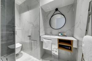 ein Badezimmer mit einem WC, einem Waschbecken und einem Spiegel in der Unterkunft 213 Suite Givenchy - Superb apartment in Paris in Paris