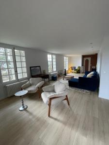 una gran sala de estar con un sofá azul y sillas en La casa du Cerisier en Veyrier-du-Lac