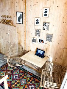 a room with a wooden wall with a laptop on a table at Hacienda Hotel in Friedrichshafen