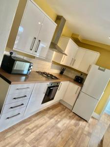 a white kitchen with white cabinets and appliances at Brooklyn Place by SG Property Group in Crewe
