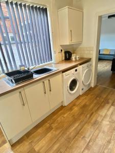 eine Küche mit Waschmaschine und Trockner in der Unterkunft Brooklyn Place by SG Property Group in Crewe