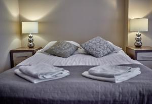 un letto con asciugamani e cuscini sopra di Apartamenty-Europejska a Suwałki