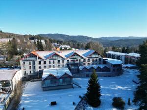 una vista aérea de un edificio en la nieve en Hotel BouCZECH en Lipno nad Vltavou