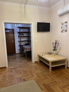 a living room with a table and a tv on the wall at luxury apartment center athens (wifi) in Athens