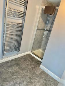 a shower with a glass door in a bathroom at Brooklyn Place by SG Property Group in Crewe