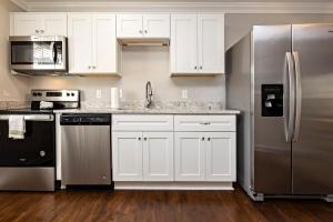una cucina con armadi bianchi e frigorifero in acciaio inossidabile di Natural Beauty A a Virginia Beach