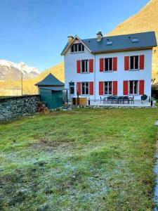 a large white house with red windows in a field at Superbe villa familiale - 1408 in Esterre