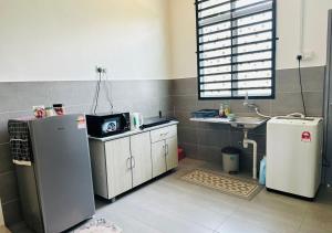a small kitchen with a sink and a refrigerator at Pekan Modern Style Home w Wi-Fi Netflix in Pekan