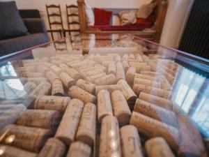 By les Climats - Au coeur du Vignoble - Fixey في Fixin: خزانة عرض مليئة بالكثير من زجاجات النبيذ