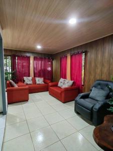 a living room with red furniture and red curtains at Casa privada en el Bosque Nuboso Del Cocora in San Ramón