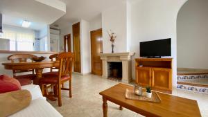 a living room with a couch and a table and a television at Apartamento Esmeralda VyB in Denia