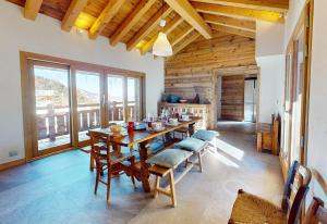 a dining room with a wooden table and chairs at Chalet La Grande Ourse Meribel - superior apartment in Les Allues