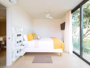 ein weißes Schlafzimmer mit einem Bett und einem Fenster in der Unterkunft Cosy villa with private pool by CanaryScape in San Bartolomé de Tirajana