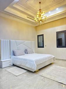 a bedroom with a large bed and a chandelier at Luxury Villa, Central Ac, Bbq, Ideal For Events in Rejiche