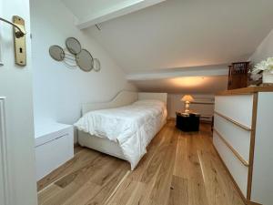 カンヌにあるChez Nellaのウッドフロアのベッドルーム1室(白いベッド1台付)