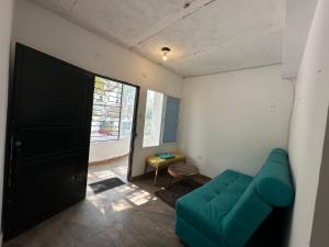 RokaDura Hostel في سانتا مارتا: غرفة معيشة مع أريكة زرقاء ونافذة
