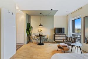 uma sala de estar com uma mesa e cadeiras e uma televisão em All in Studio with Private Parking City Lux ID219 em Luxemburgo