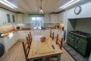 a kitchen with a wooden table and a green oven at Hadrians Wall Cottage, Greenhead in Greenhead