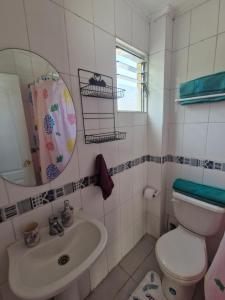 Un baño con inodoro, lavabo y espejo. en Esmeralda, en Antofagasta