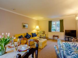 salon z żółtą kanapą i telewizorem w obiekcie 3 Bed in Branscombe 78002 w mieście Branscombe
