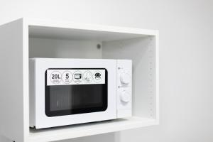 a white microwave oven in a white kitchen at U Wandy in Trzęsacz